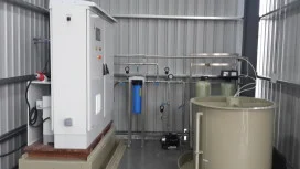 Envirolyte generator cabinet beside filtration components and a cylindrical process tank