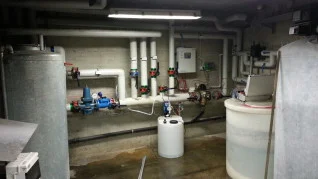 Hotel plant room with water tanks, pumps, pipework and dosing equipment