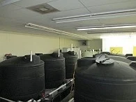 Row of black solution storage tanks at the Houston installation