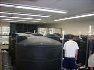 Large black anolyte and catholyte storage tanks inside the Houston facility