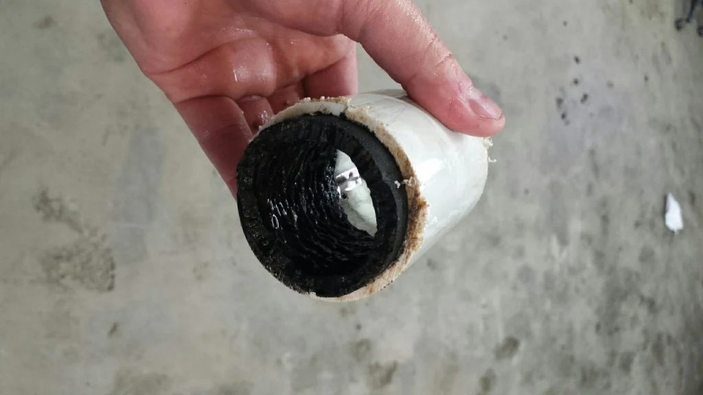 Interior of a water pipe shown before anolyte dosing with visible dark deposits